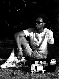 a man sitting on the ground with a laptop