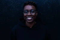 a black woman wearing glasses and a black hoodie