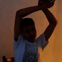 a man in a white t - shirt standing in front of a chair